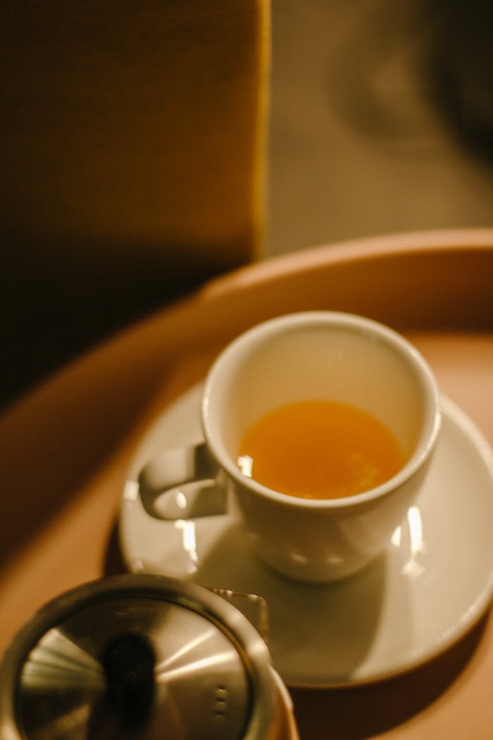 why-choose-us Warm cup of tea on a saucer, placed on a wooden tray, perfect for relaxation.
